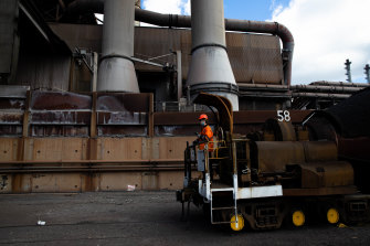 A BlueScope worker sits at the front of one of the company’s “torpedoes”, a wagon that takes 180 tonnes of molten iron per tube from the blast furnace to a steel-processing plant.
