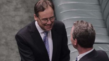 Environment Minister Greg Hunt is congratulated by Leader of the House Christopher Pyne after the Carbon Tax Repeal bills passed the House on the voices at Parliament House on Thursday 21 November 2013. Photo: Andrew Meares