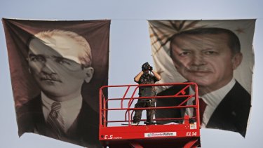 A policeman between portraits of Turkish President Recep Tayyip Erdogan, right, and the republic's founder, Mustafa Kemal "Ataturk".