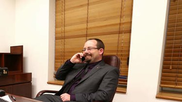 Senator Ricky Muir gives his wife a ring after the schoolkids bonus was saved during the repeal of the mining tax, in his office at Parliament House. Photo: Alex Ellinghausen
