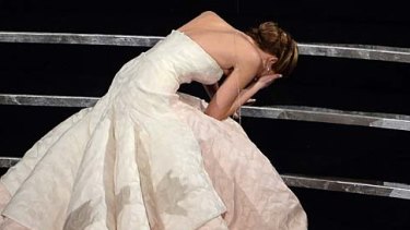 Jennifer Lawrence trips on her way to the stage.
