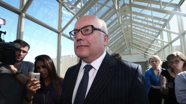 Attorney-General Senator George Brandis  departs after addressing the media in the press gallery on Thursday.