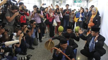 Ibrahim Mat Zin, bottom right, performs a ritual that he says will help rescuers find the plane.