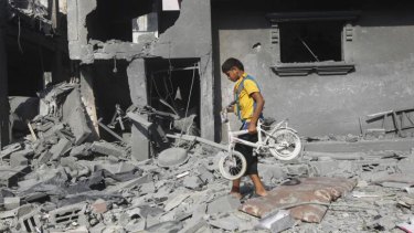 A Palestinian boy carries a bicycle from the wreckage of a building in the southern Gaza Strip city of Rafah on Saturday.