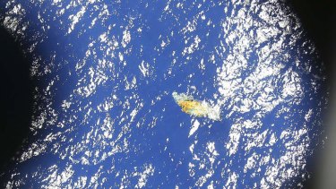 A piece of unknown debris floats just under the water in this image taken by a Royal New Zealand P3 Orion while it searches for missing Malaysia Airlines Flight MH370, over the Indian Ocean.