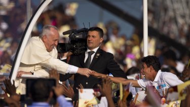 Ecstatic welcome ...  A devotee stretches out his hand to touch Pope Francis.