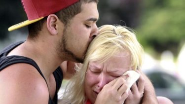 Two people comfort each other as they await word about the safety of students after a shooting at Reynolds High School.