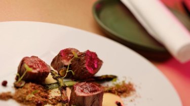 Wallaby fillet with white asparagus cream, charred green asparagus, wattleseed soil and wild blueberries at Sarti, in the city.