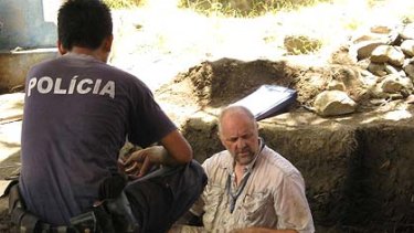 Jon Sterenberg from the Victorian Institute of Forensic Medicine sits in a possible grave from the Dili massacre.