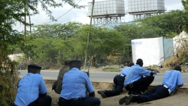 Kenyan police officers take cover outside the Garissa University College during the attack.