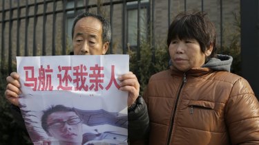 A couple who lost a son on Malaysia Airlines Flight 370 that went missing on March 8, 2014, protest near the Malaysian Embassy in Beijing to demand the Malaysian government keeps searching for the missing plane.