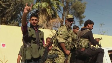 In this image made from video posted online by Qasioun News Agency, members of a Turkey-backed Syrian opposition force patrol in Dabiq, Syria.