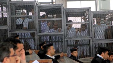 On trial: Al-Jazeera reporter Australian Peter Greste appeared in court in a caged dock, centre facing out.