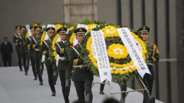 Chinese soldiers carry wreaths at a ceremony to mark the 75th anniversary of the Nanjing massacre.
