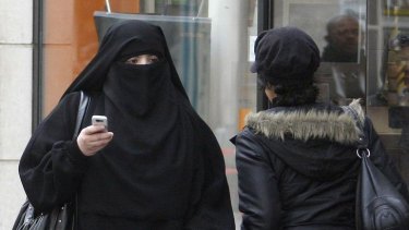 A woman wears a burqa as she walks on a street in Saint-Denis, near Paris in this April 2, 2010 file photograph. France's ban on full face veils, a first in Europe, went into force on April 11, 2011, exposing anyone who wears the Muslim niqab or burqa in public to fines of 150 euros ($216). REUTERS/Regis Duvignau/Files (FRANCE - Tags: POLITICS RELIGION)