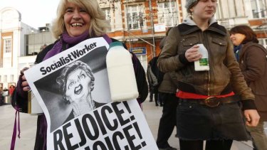 Revellers hold up posters to celebrate the death of Britain's former prime minister Margaret Thatcher.