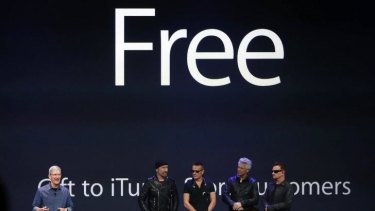 Free for all: Apple CEO Tim Cook and the band onstage at the product launch where the biggest giveaway in the history of rock was announced.