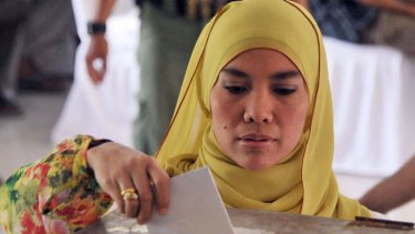 A Jakarta resident casts her vote at a polling station during the legislative election on Wednesday.