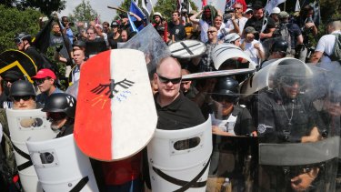 White nationalist demonstrators use shields as they guard the entrance to Lee Park.
