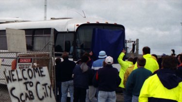 Picketers stand in front of a bus trying to pass through. A sign reads "Welcome to Scab City" at Webb Dock, Melbourne. April 8, 1998.