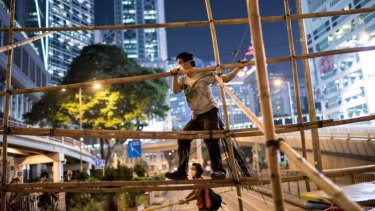 Pro-democracy protesters using bamboo to strengthen a barricade on Monday night.