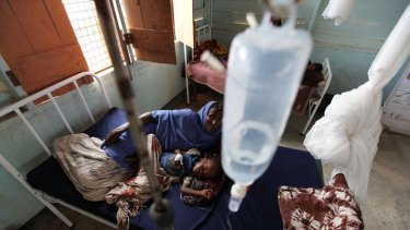 A mother cares for her child suffering from malaria in a medical clinic at Dadaab refugee camp, Kenya. Malaria is the number one killer of children in Africa.