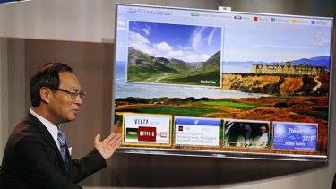 Panasonic chief Kazuhiro Tsuga shows off one of his company's Smart TVs.