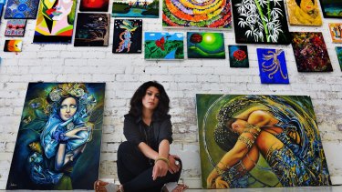 Leila Ashiani, an Iranian artist who survived the sinking of a boat carrying asylum seekers, with two of her works. 