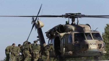 Israeli army soldiers carry a labourer shot near the Israel and Gaza border to a helicopter.