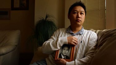 A worried Tommy Du holds a picture of his father, jailed in China.
