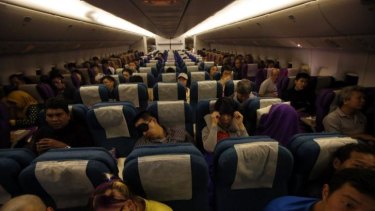 Passengers remain in their seats on-board Malaysia Airlines flight MH318 as it cruises towards Beijing over the South China Sea.