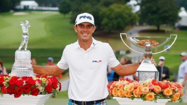 The spoils: Billy Horschel poses on the 18th green after winning both the Tour Championship and the FedEx Cup play-offs.