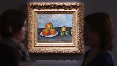 Visitors talk near Paul Cezanne's 'Les Pommes,' which sold for $A41 million at auction in New York.