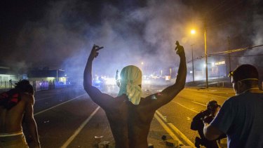 Injustice's offspring: Protesters face off with police after tear gas was fired at crowds in Ferguson, Missouri.