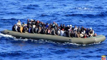 A makeshift boat filled with migrants which was spotted by an Italian Navy ship, in the Mediterranean sea near Lampedusa.