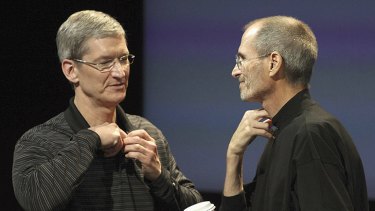 Outgoing Apple CEO Steve Jobs (right) appears on stage with his anointed successor, Tim Cook, at news conference at the company's Cupertino headquarters.