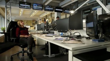 Employees sit in front of the black screens of shut down computers at French television network TV5Monde newsroom at their headquarters in Paris on Thursday after hackers shut down the television network.