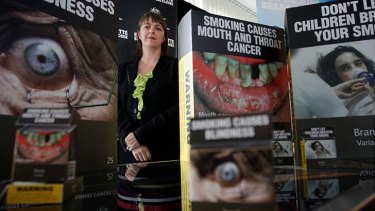 Attorney-General Nicola Roxon with examples of the tobacco plain packaging and warning signs.