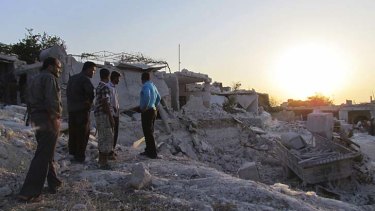 Aftermath: Residents of Iskat inspect buildings damaged by aircraft belonging to forces said to be loyal to Bashar al-Assad.