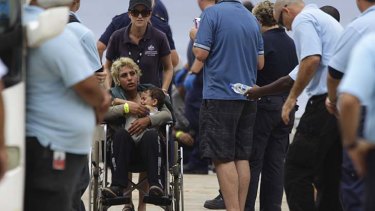 Long journey: A mother and her child are escorted by customs staff on Christmas Island on Thursday. Almost 1000 people arrived at the island this week.