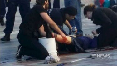An injured bystander is treated after being caught in crossfire when police shot at Jerry Sourian at Westfield Hornsby.