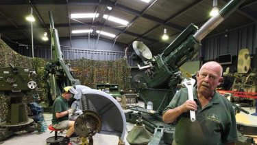 Reconstruction ... Ray Bell and Roy Mellier, both volunteers, work on a World War II anti-aircraft gun.