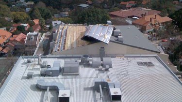 The roof of an office block in North Sydney is blown off during today's strong winds.