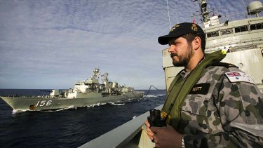 Able Seaman Maritime Logistics Steward Kirk Scott keeps watch on the forecastle of  HMAS Success as they conduct a Replenishment at Sea with HMAS Toowoomba while both ships are deployed in search of the missing Malaysia Airlines Flight MH370 in the southern Indian Ocean.
