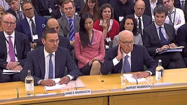James and Rupert Murdoch face a British parliamentary inquiry into phone hacking last night. Rupert Murdoch's wife, Wendi Deng, watches in the background.