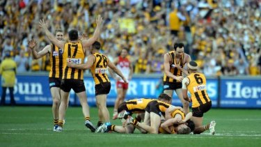 The moment of triumph: Hawthorn players raise their arms in jubilation as the final siren sounds on Saturday.