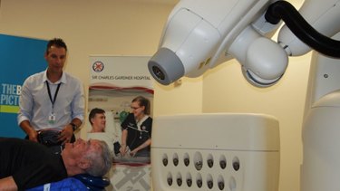 Lung cancer patient David Burton is treated with the CyberKnife under radiation therapist Peter Podias's observation.