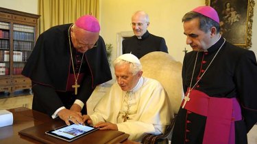 Pope Benedict XVI is shown how to use an iPad in 2011.