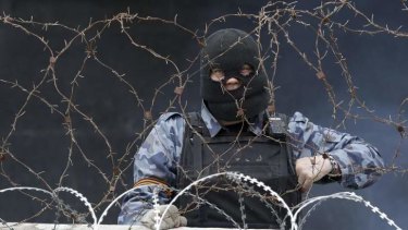 A pro-Russia protester stands at a barricade outside a regional government building in Donetsk, on April 10, 2014.