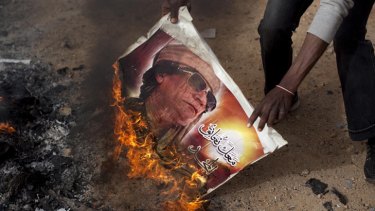 Protesters burn posters of Gaddafi during demonstrations in Benghazi.